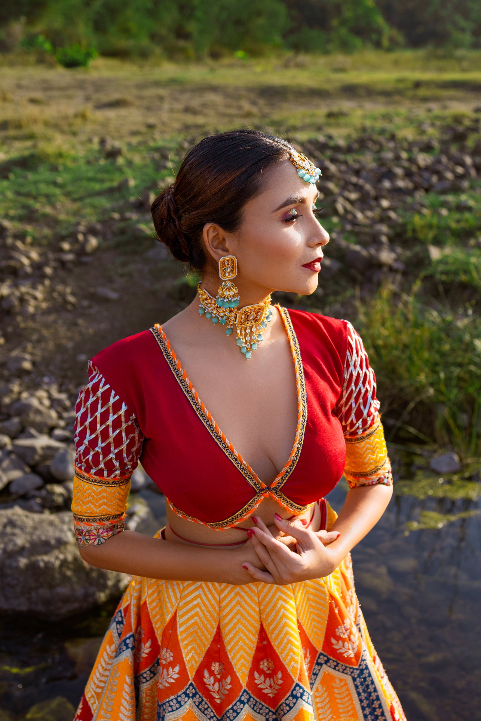 Hitakshi Chatterjee in a red and mustard festive lehenga, side profile with kundan jewellery
