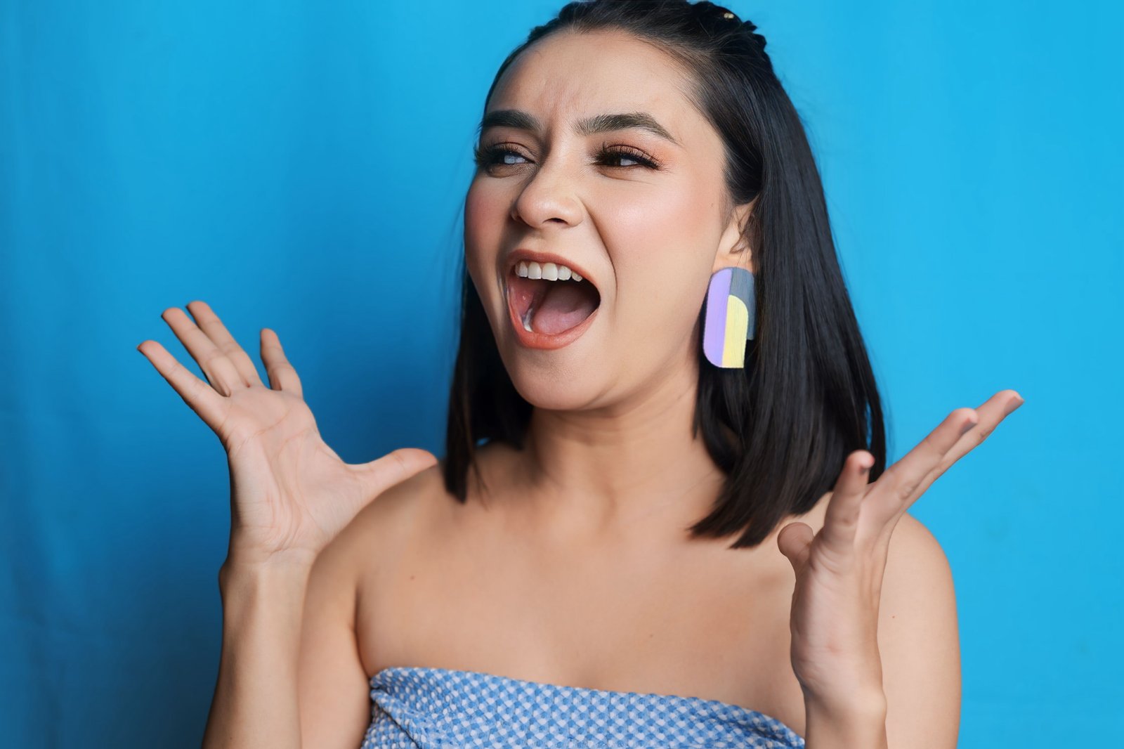 Hitakshi Chatterjee laughing against a blue backdrop, expressive UGC-style shoot