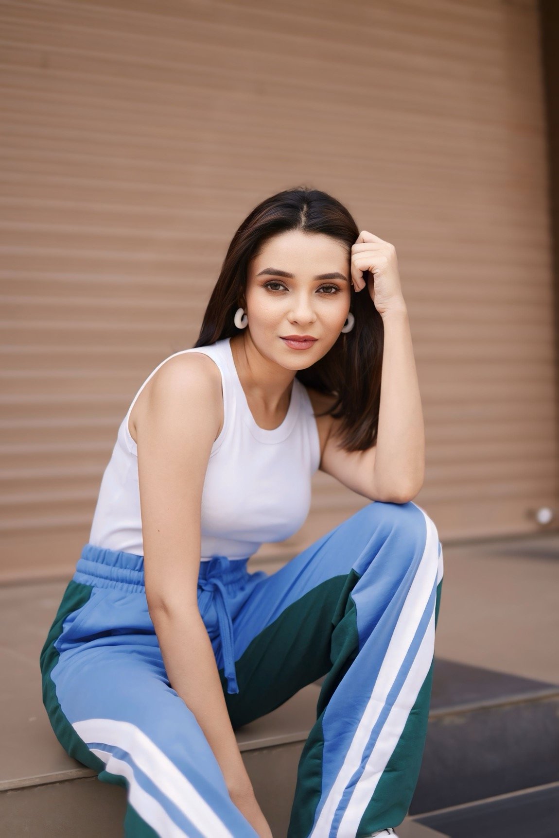 Hitakshi Chatterjee in a white top and blue colour-block track pants