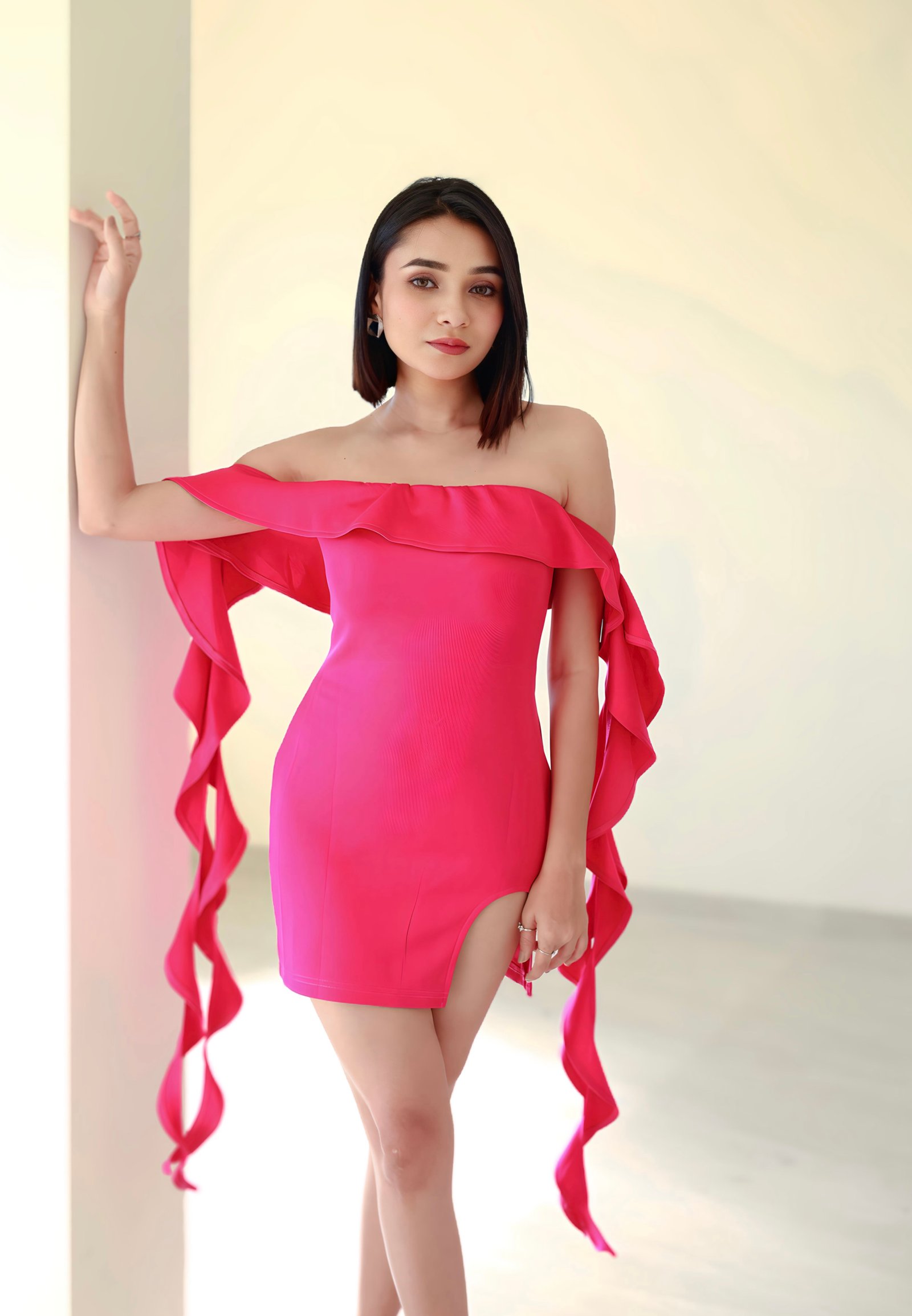 Hitakshi Chatterjee in a hot pink ruffle-sleeve mini dress, close-up portrait