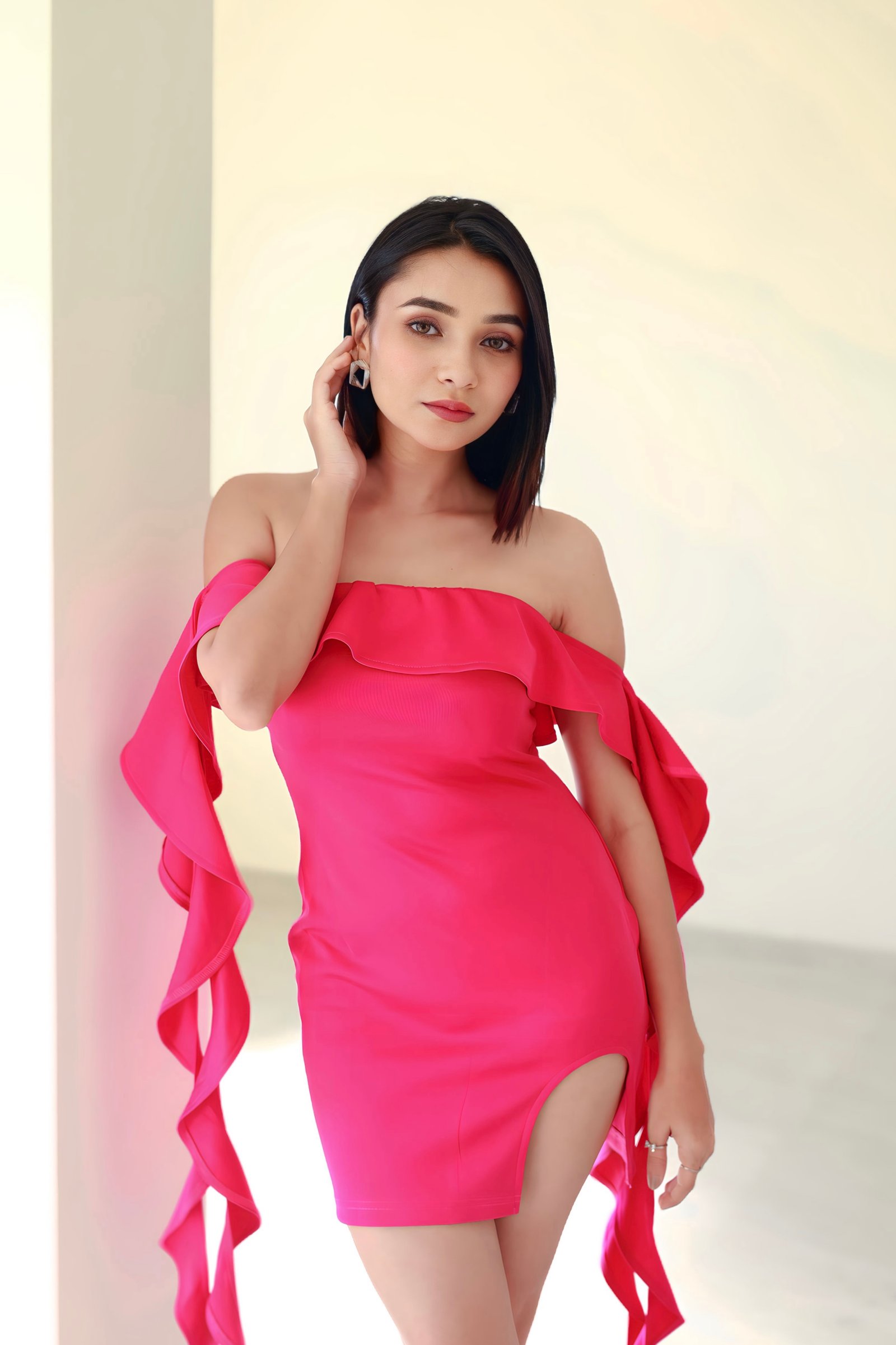 Hitakshi Chatterjee in a hot pink ruffle-sleeve mini dress, close-up portrait