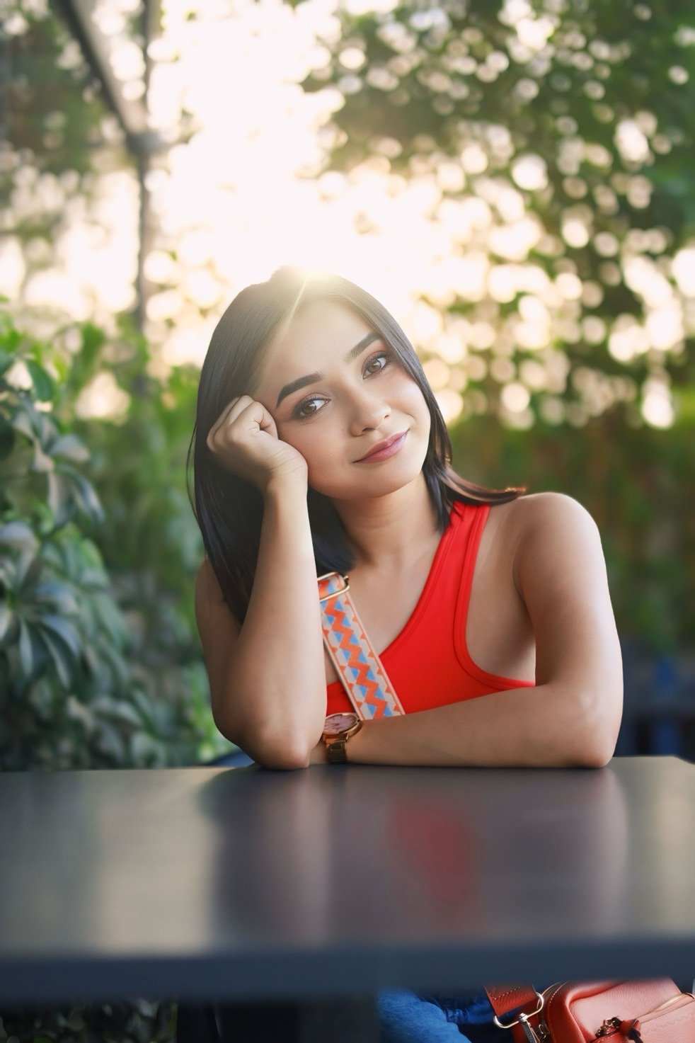 Hitakshi Chatterjee smiling at a café table, golden hour lifestyle shoot