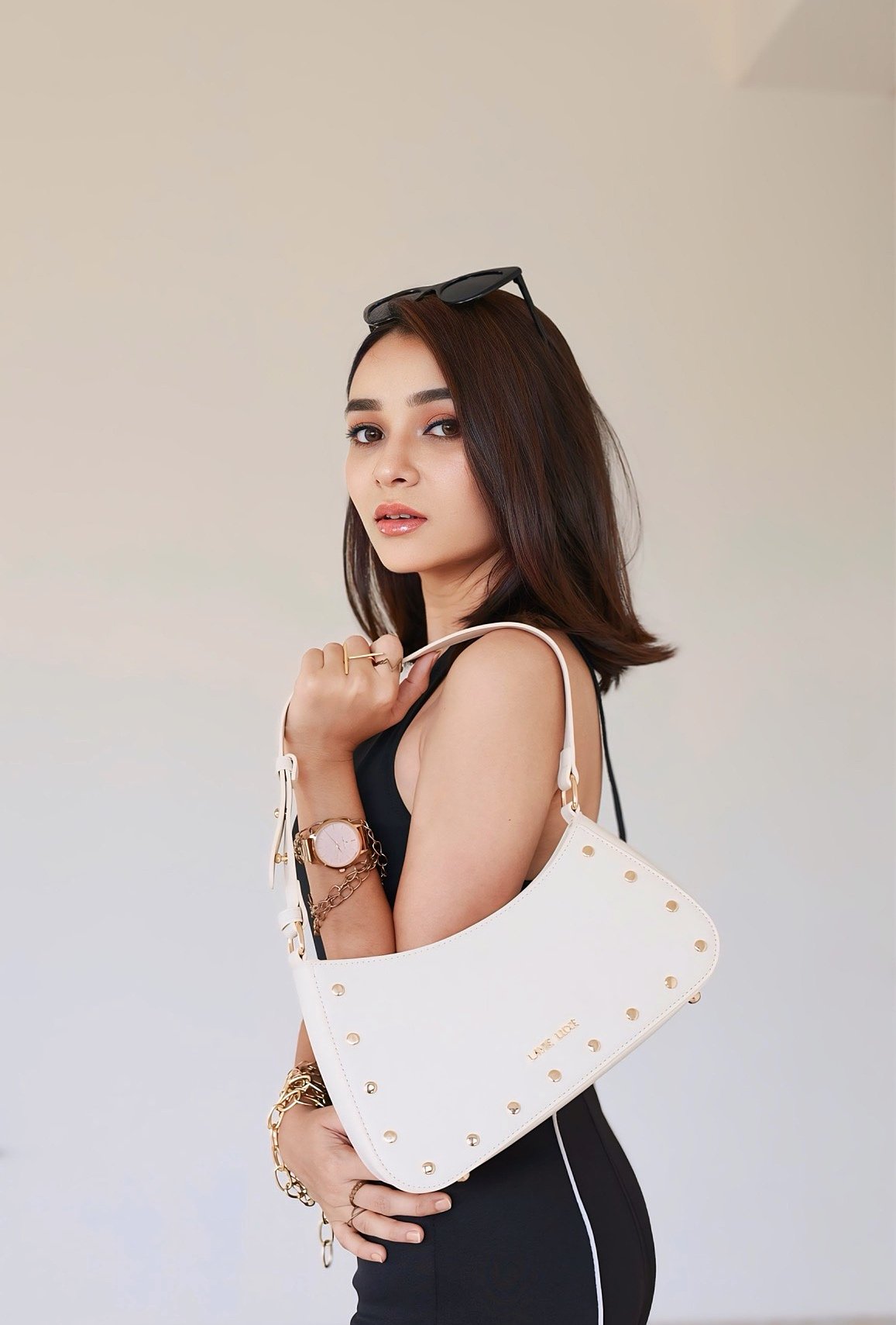 Hitakshi Chatterjee with a white studded handbag and sunglasses, accessory styling