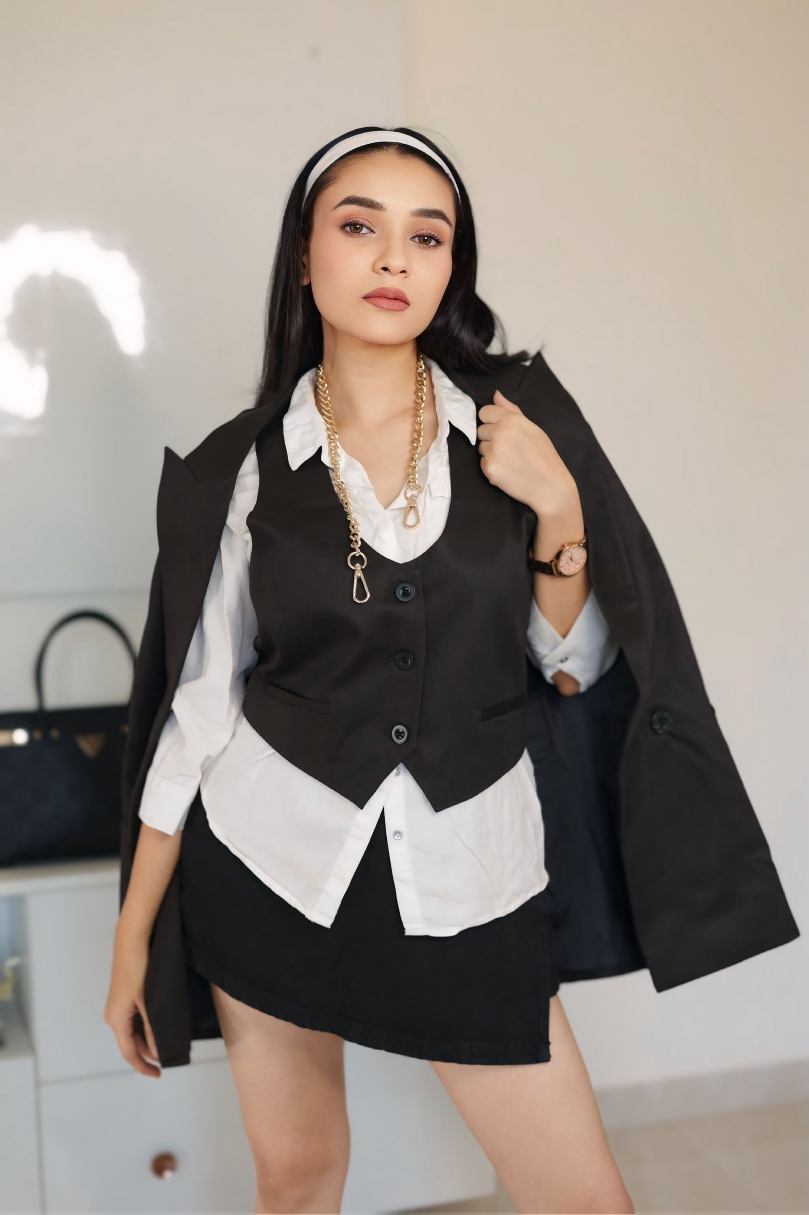 Hitakshi Chatterjee in a monochrome vest and blazer with gold chain jewellery